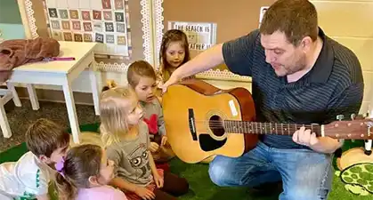 Dad playing Guitar to children